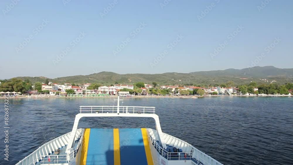 View on water surface behind ferryboat that is crossing over calm sea.
