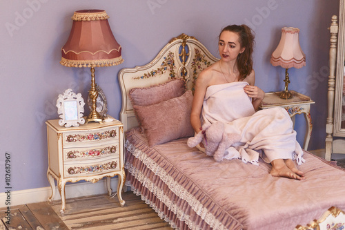 girl in a plaid sits on a bed photo