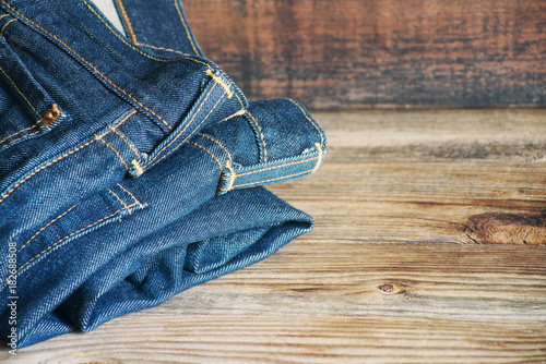 Blue jeans on a wooden surface, close up