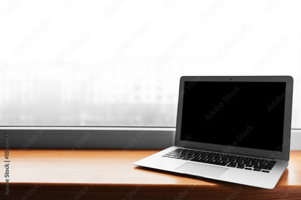 laptop with blank screen on wood table with office window view backgrounds laptop with blank screen on wood table with office window view backgrounds