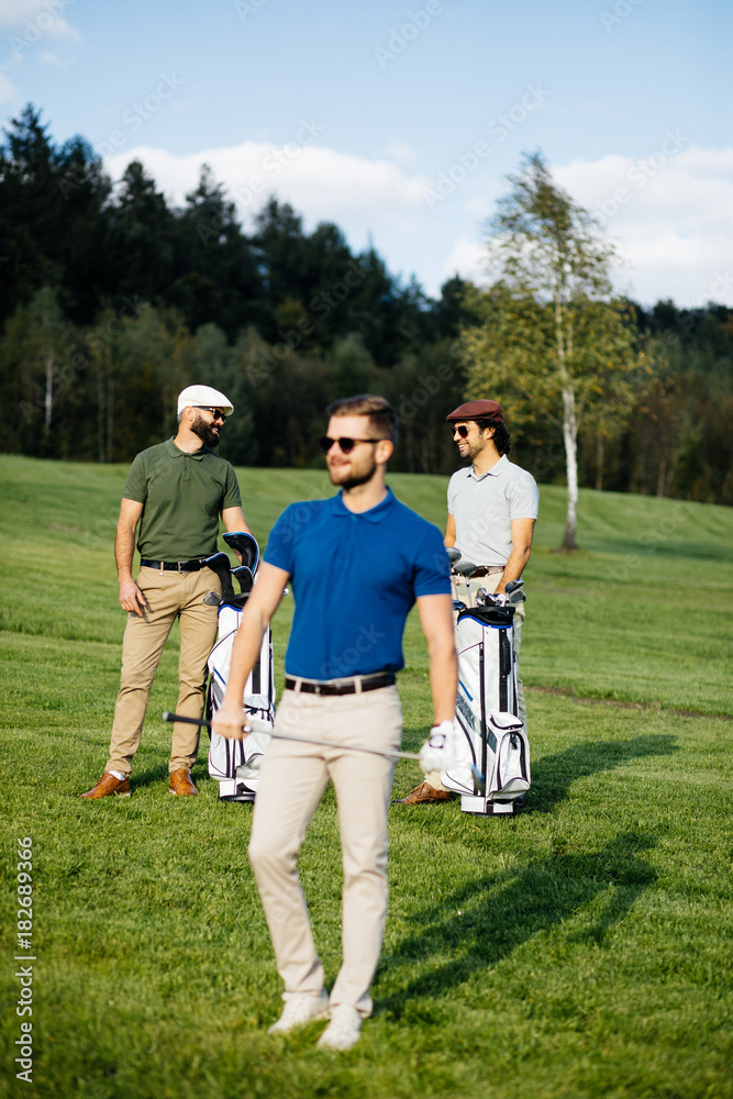 Golf player walking and carrying bag on course during summer game golfing Golf player walking and carrying bag on course during summer game golfing