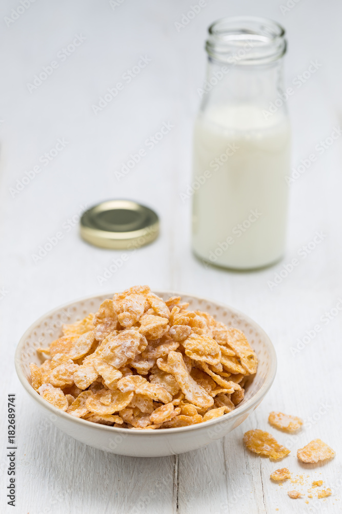 Cornflakes in einer Schale und Milchflasche Cornflakes in einer Schale und Milchflasche