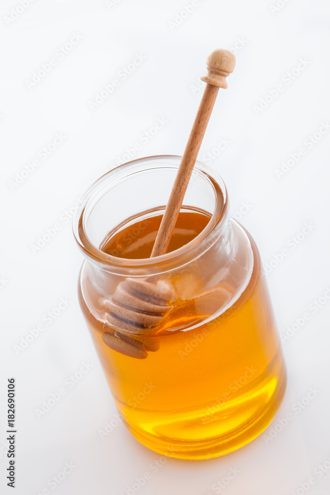 jar of honey with honeycomb on white jar of honey with honeycomb on white