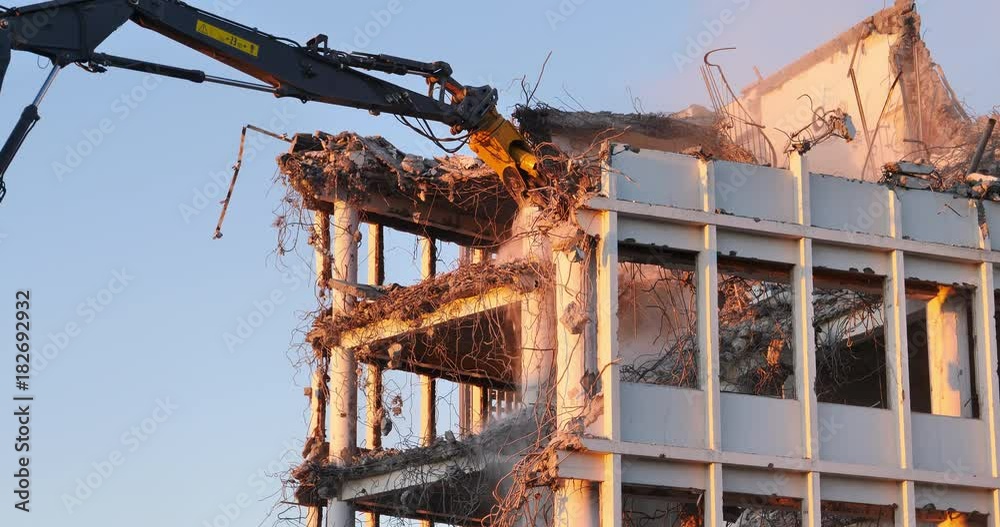 Crane excavator demolition, Islandsbanki building gutted Reykjavik Iceland falling debris