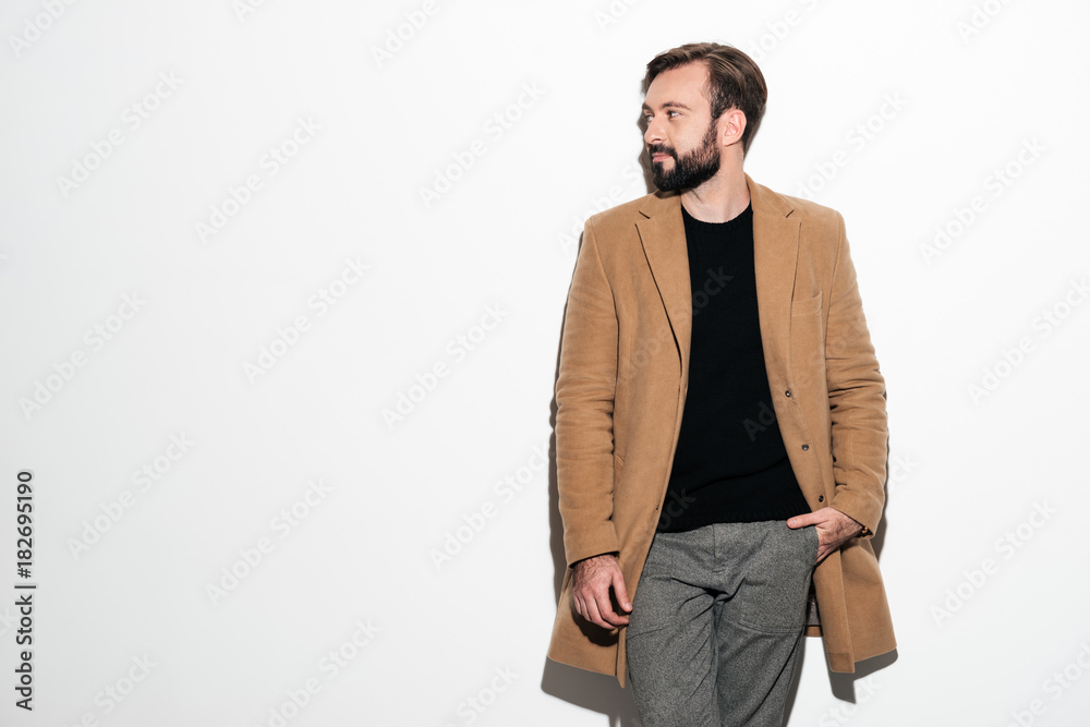 Fototapeta premium Portrait of a stylish bearded man dressed in a coat