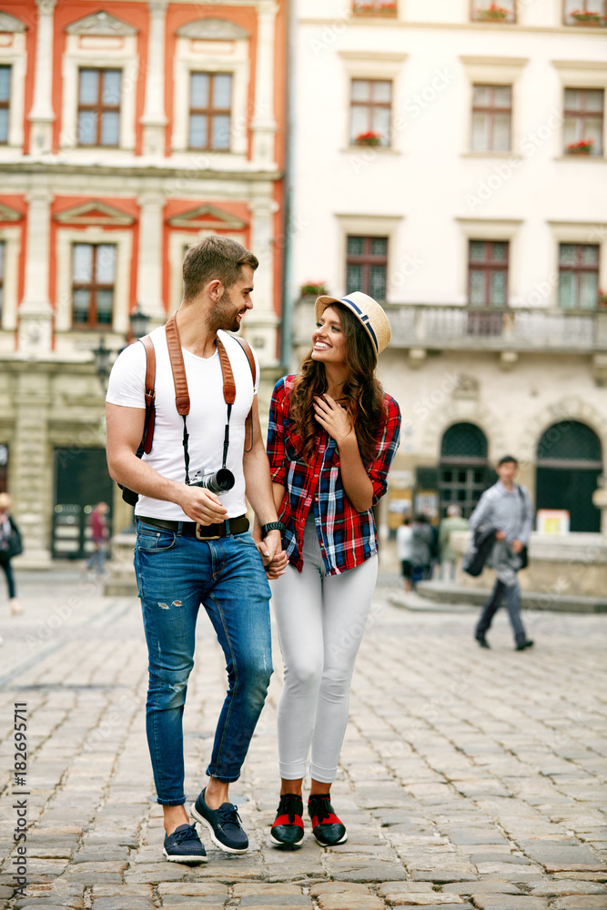 Obraz premium Beautiful Tourist Couple In Love Walking On Street Together.