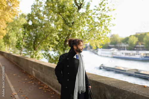 Half Nigerian man strolling near river. photo