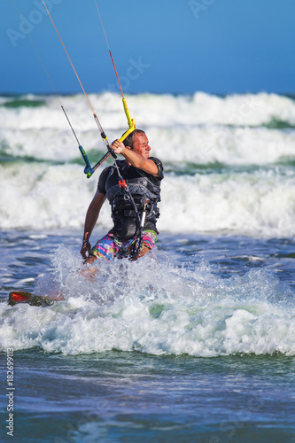 Young atletic man riding kite surf on a sea © AnnaMoskvina