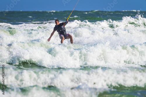 Young atletic man riding kite surf on a sea