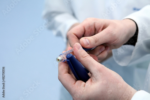 Insulin cartridge and ampoule in the hands of a doctor. The doct