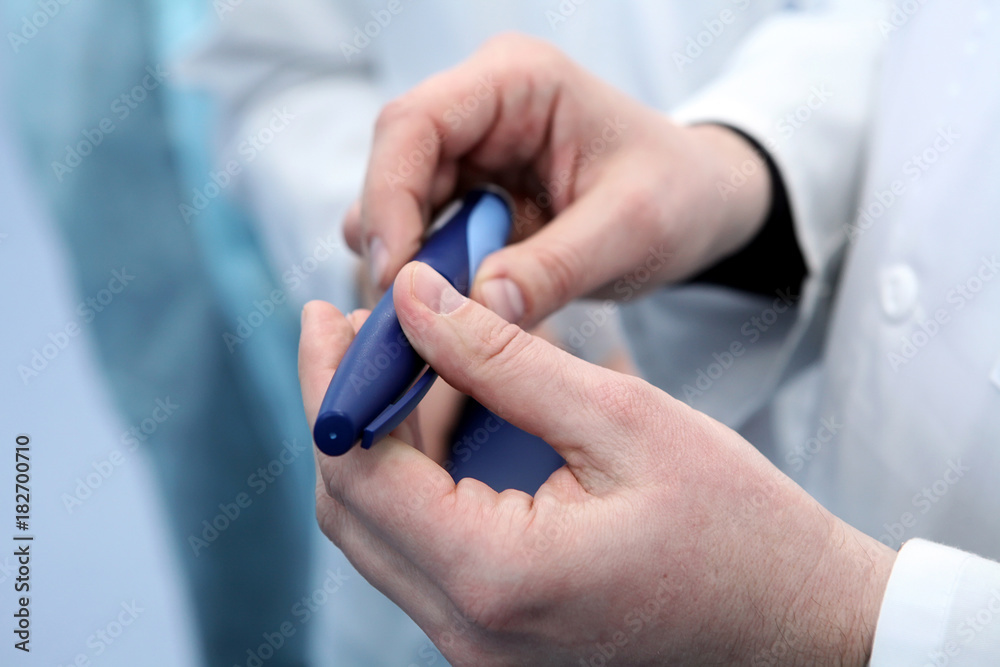 Insulin cartridge and ampoule in the hands of a doctor. The doct Insulin cartridge and ampoule in the hands of a doctor. The doct