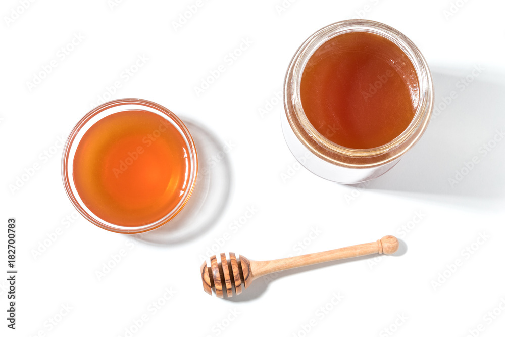 Honey dipper and honey in jar on white background. Honey dipper and honey in jar on white background.