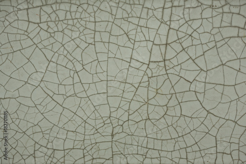Old cracked white tile, black cracks, texture.