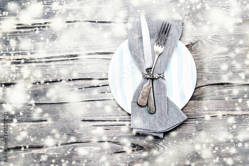 Christmas Dining table setting with decorations on grey table. Holidays background with copyspace.