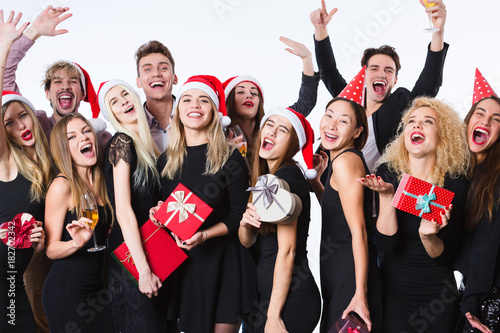 Happy young friends in black cloth standing over white background and having fun.