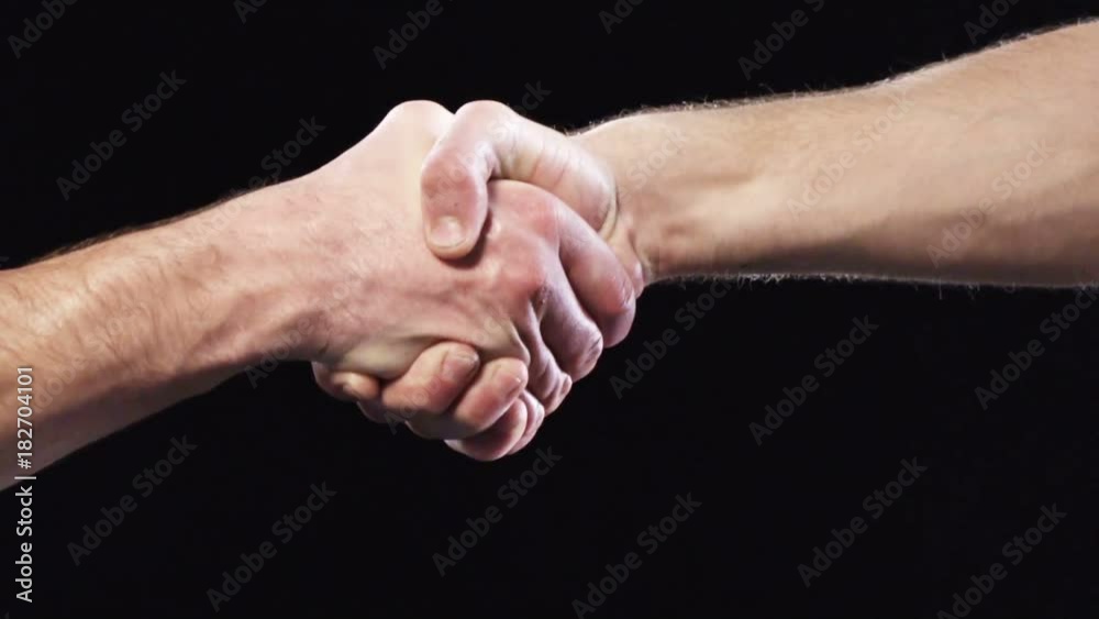 Cropped image of undressed strong man hands shaking over black background Cropped image of undressed strong man hands shaking over black background