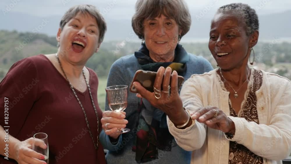 Diverse group of multi racial senior women take a selfie with smartphone
