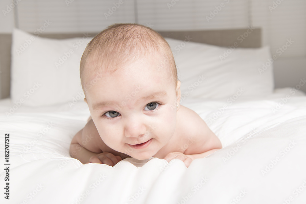 Cute baby on the white bed