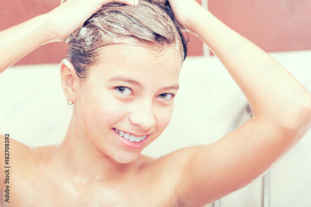 Naklejka premium Teenage girl in bathroom is showering. Morning and evening hygiene