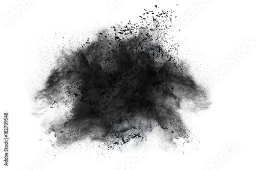 Black powder explosion against white background.The particles of charcoal splatted on white background. Closeup of black dust particles explode isolated on white background. photo