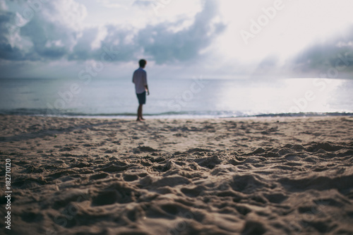 young man walking on the beach.