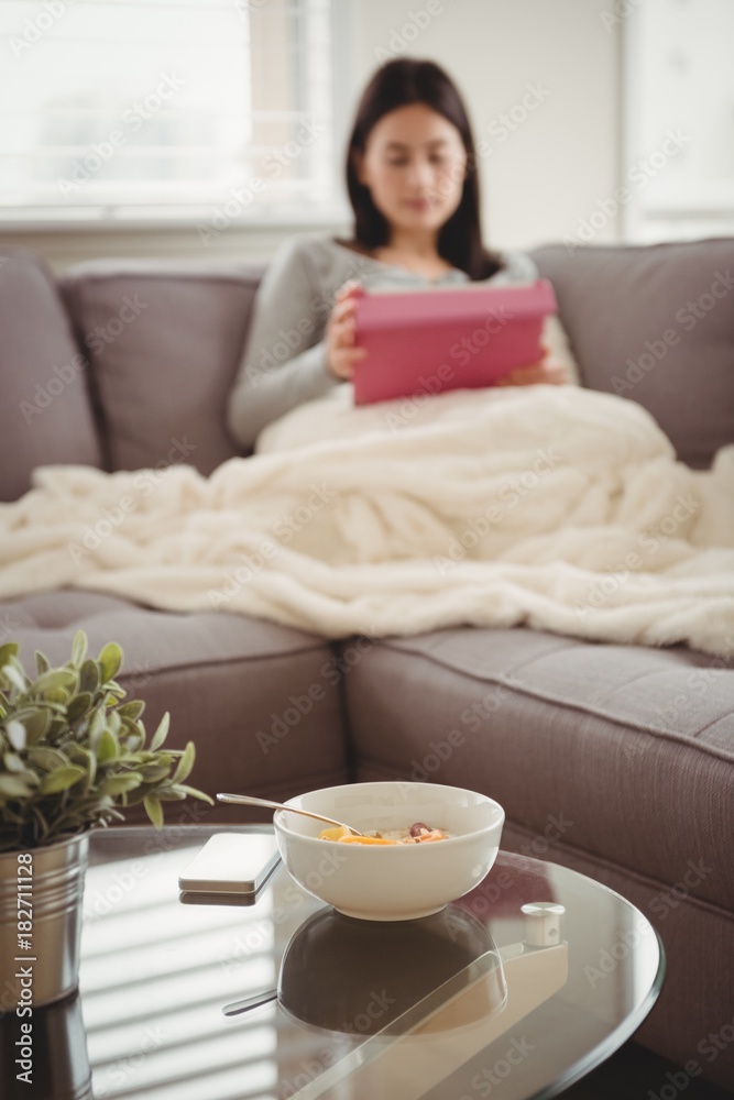 Close up breakfast on table while woman sitting on sofa Close up breakfast on table while woman sitting on sofa