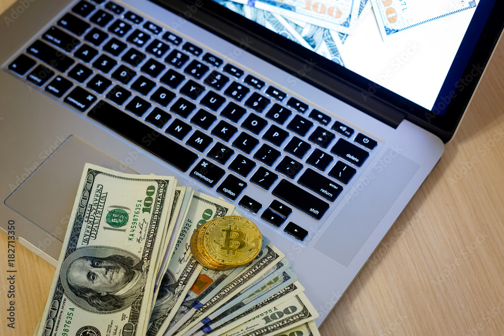 Bitcoin golden coins on a dollar banknotes office background white laptop mobile Bitcoin golden coins on a dollar banknotes office background white laptop mobile
