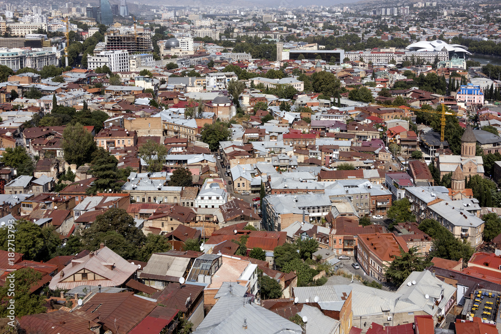 Kingdom of Georgia, Tbilisi (Tiflis): Skyline with red roofs of the Georgian capital with river, houses, churches and horizon in the background. 