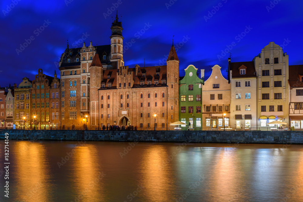 View of Gdansk's old Town and Brama Mariacka (Maria's Gate) from the Motlawa River at night. Poland, Europe.