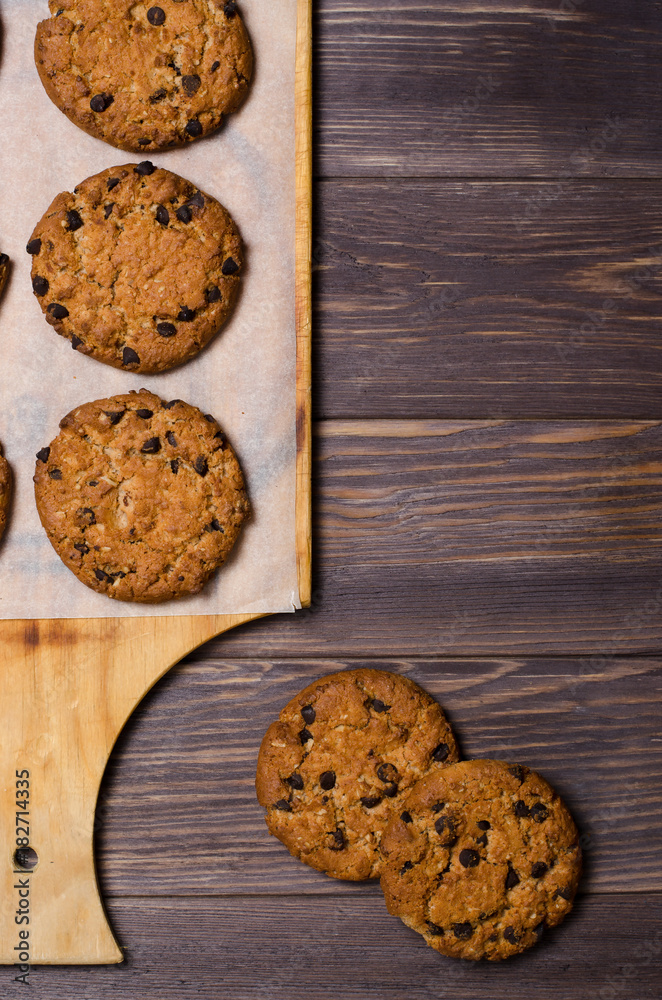 Homemade oatmeal cookies on a wooden cutting Board. Wooden background. Vertical photo Homemade oatmeal cookies on a wooden cutting Board. Wooden background. Vertical photo