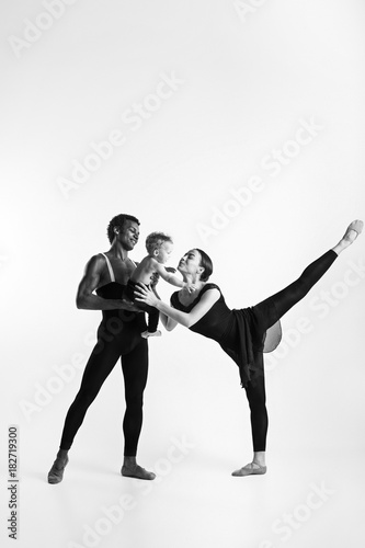 A happy family of ballet dancers on white studio background
