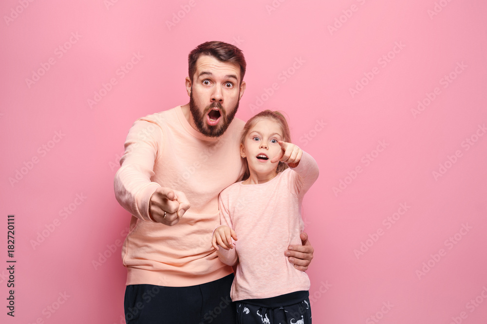 Surprised young family looking at camera on pink Surprised young family looking at camera on pink