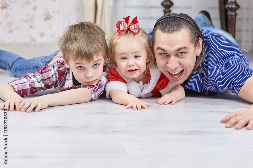 Father with children playing in Christmas living room Father with children playing in Christmas living room
