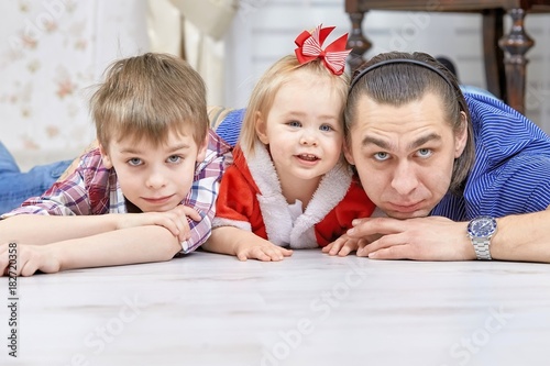 Father with children playing in Christmas living room