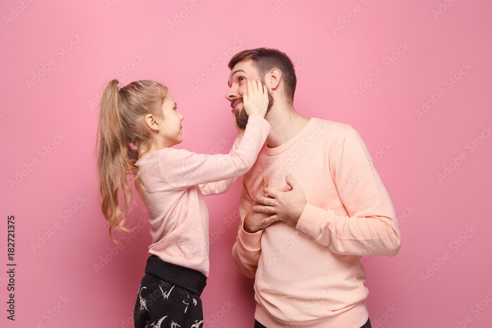 Young father with his baby daughter. The kid in preschool age pointing with finger - obrazy, fototapety, plakaty 