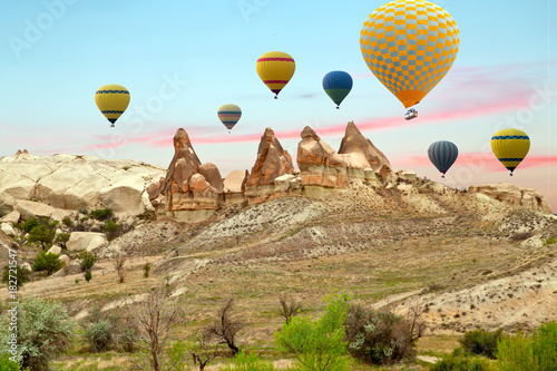 Hot air balloons flying in sunset Volcanic rock formations in Cappadocia, Anatolia, Turkey.