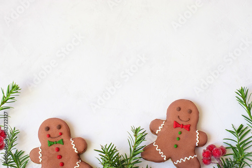 Two gingerbread man with candy standing on a white background. Christmas card