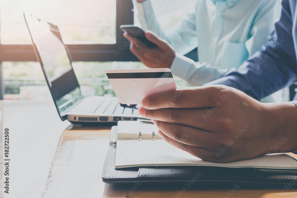 Businessman holding credit card and using laptop. Making payment while online shopping. E-commerce and modern technology concept Businessman holding credit card and using laptop. Making payment while online shopping. E-commerce and modern technology concept