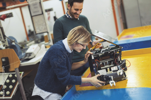 Young attractive students of mechatronics working on project © NDABCREATIVITY