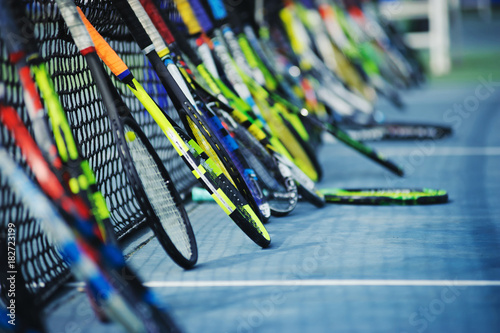 tennis rackets or tennis racquets leaning against tennis court background © OHishi_Foto