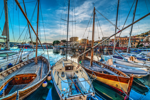 Wooden boats in La Maddalena harbor at sunset