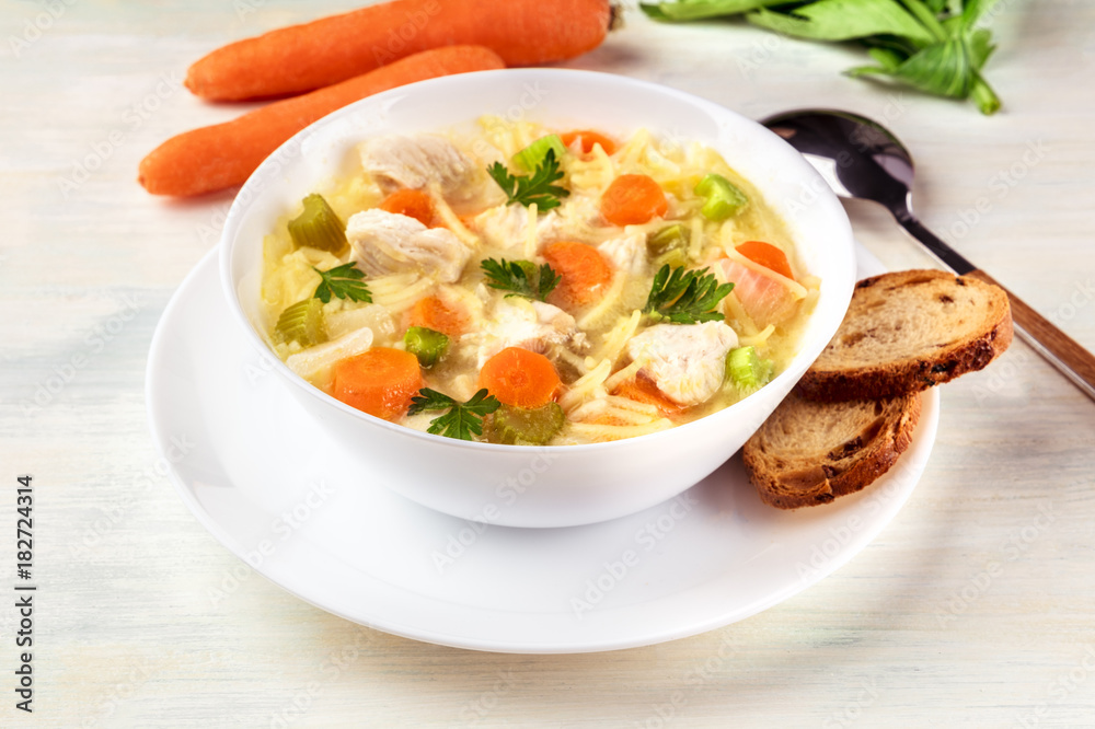 Chicken soup with noodles, bread, and copy space