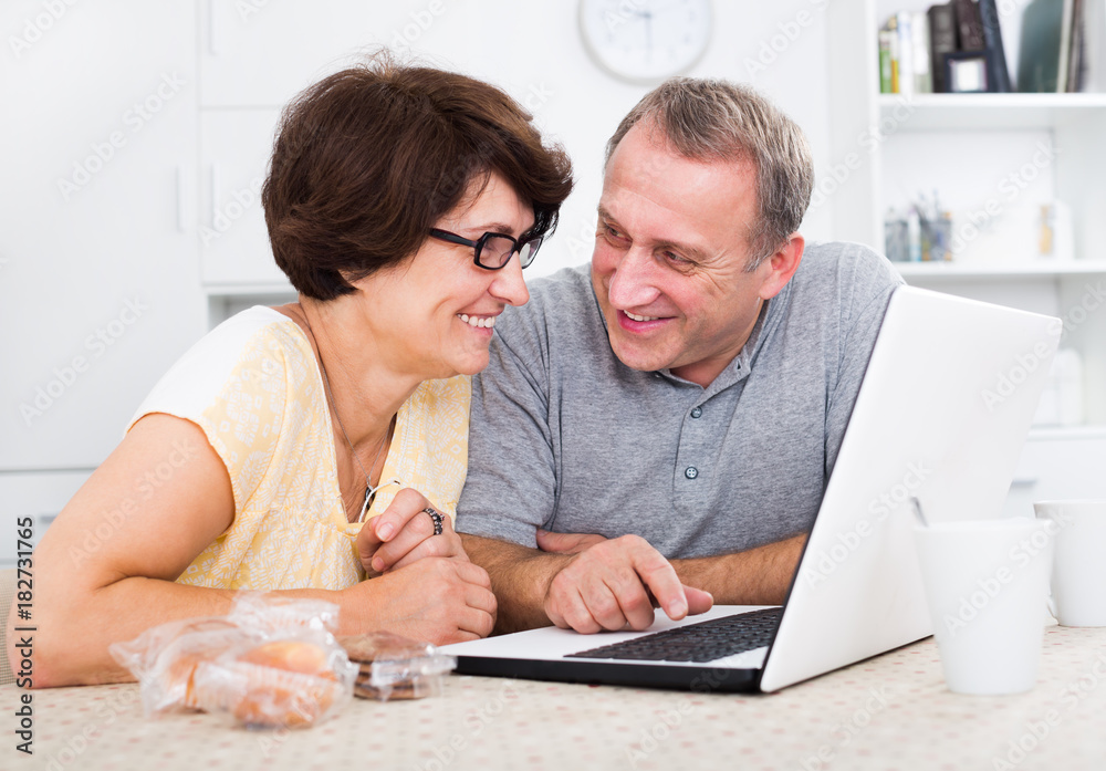 Mature man and woman looking at laptop