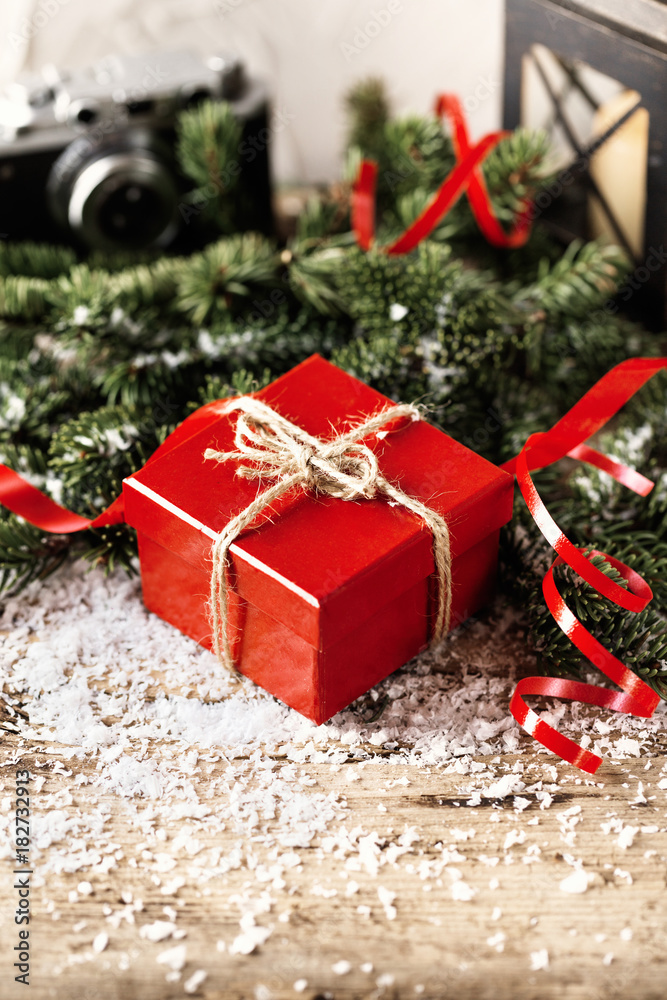 Red present gift box with camera and candle holder on wooden background Christmas New Year composition Red present gift box with camera and candle holder on wooden background Christmas New Year composition