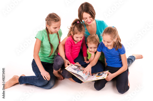 Mother reading a book to children isolated