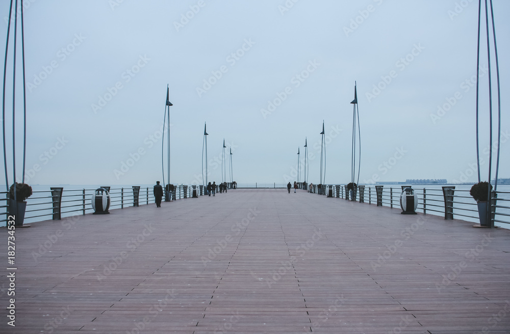 Pier on the Baku Boulevard near Milli Park. View on the Caspian Sea. National Park in Baku in the gray winter day.