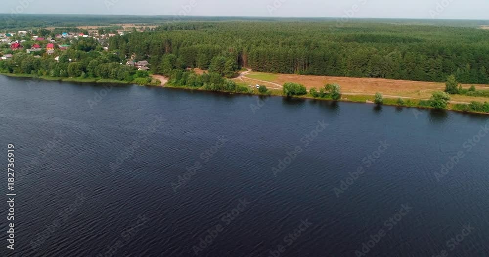 Village on Volga river aerial view from flying quadcopter over forest. Landscape panorama. Beautiful nature. Horizon in the background of fields of meadows and sky. Village on Volga river aerial view from flying quadcopter over forest. Landscape panorama. Beautiful nature. Horizon in the background of fields of meadows and sky.