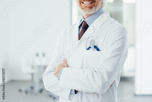 Confident doctor posing with folded arms