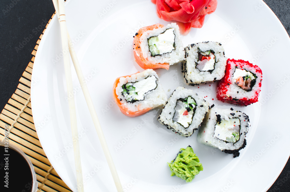 on the plate is white, lined with different rolls, sushi on the plate is white, lined with different rolls, sushi