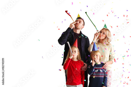 Family blowing party trumpets with confetti